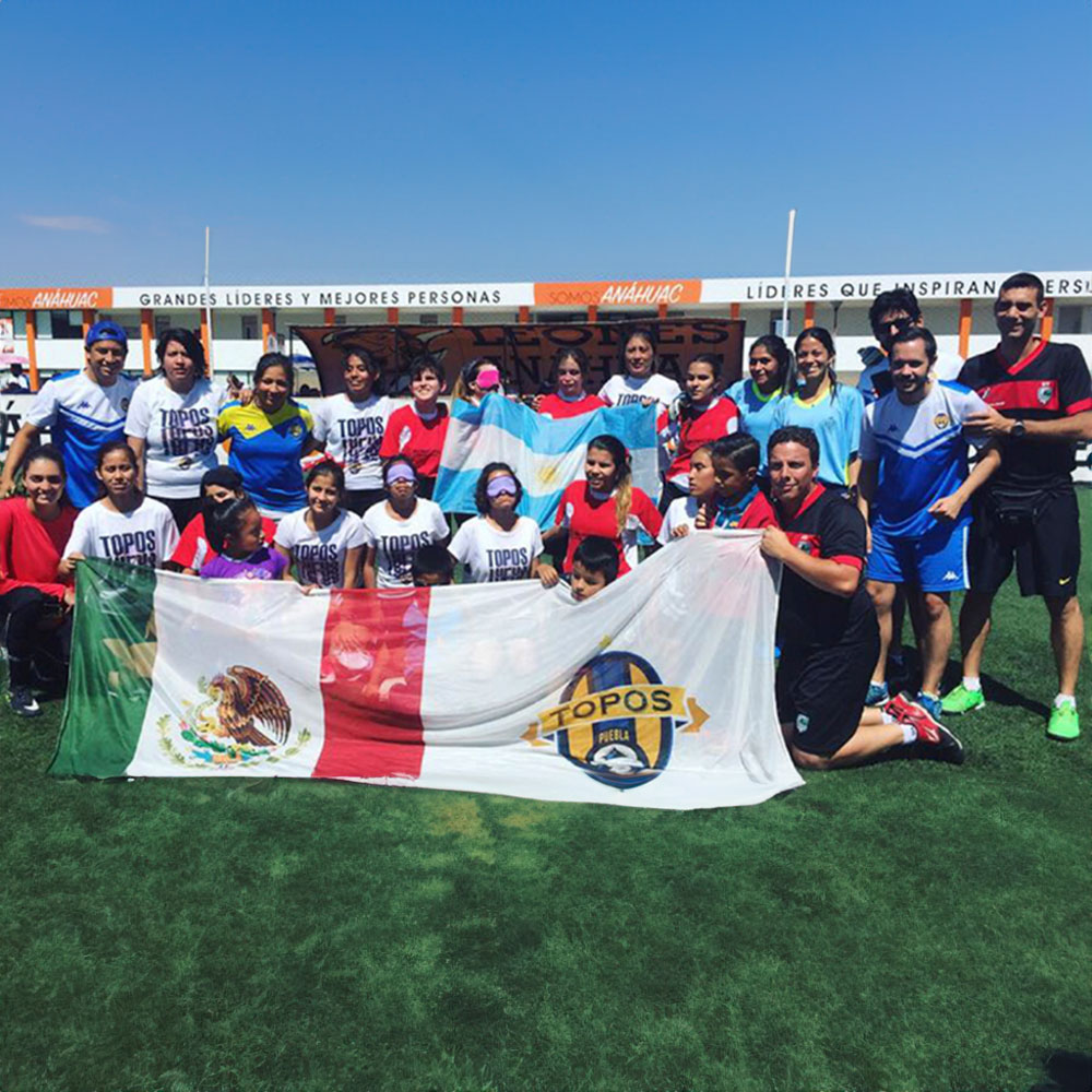 Imagen de jugadores de Topos fc sosteniendo la bandera de mexico y otra con el logo de topos fc